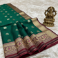 Green and maroon saree with intricate patterns on a tiled floor