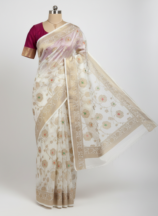 white  bnarasi organza saree ith golden zari work and red and green mina work .