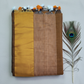 "Elegant Linen Cotton Saree featuring a rich golden zari patta border, beautifully finished with tassels on the pallu, available in vibrant colours."