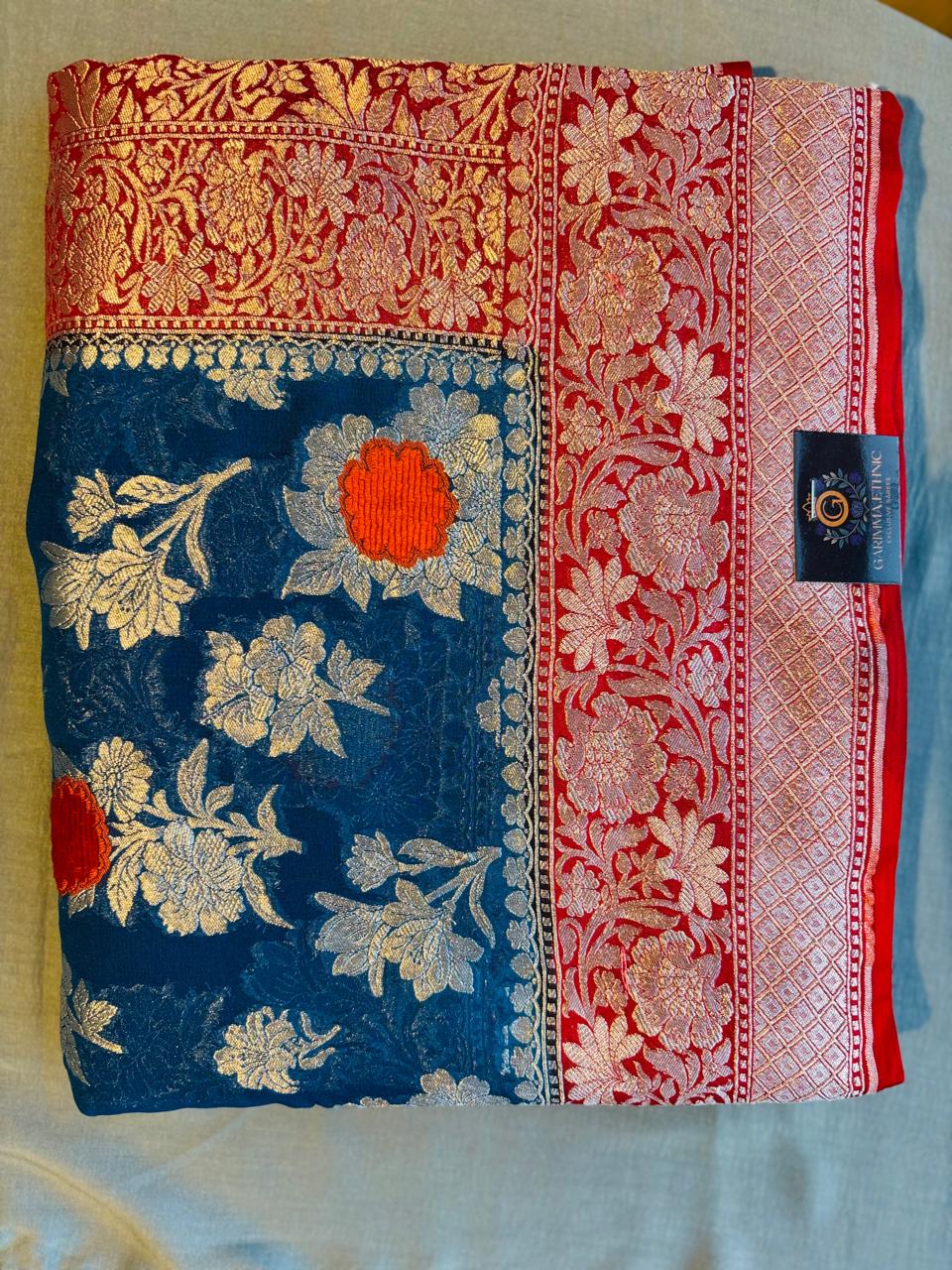 Pure khaddi goergette royal blue color banarasi saree with contrast very fresh red color .with silver zari work and velvet mina work
